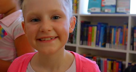 Smiling Schoolgirl in Library Brings Cheerful Learning Vibe
