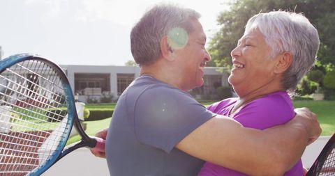 Senior Couple Celebrating on Tennis Court