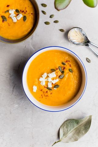 Creamy roasted butternut squash soup garnished with feta and pumpkin seeds for autumn meals