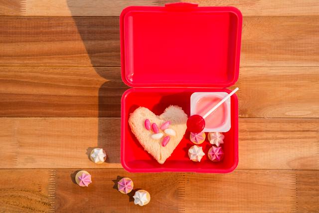 Close-up of various sweet food in lunch box on wooden table