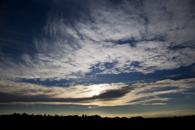 Scenic Sunset with Dramatic Cloudscape Over Tree Lined Horizon - Download Free Stock Photos Pikwizard.com
