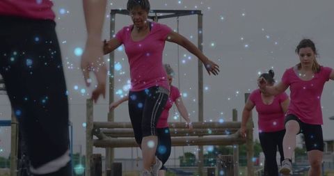 Group of Women Conquering Obstacles in Bootcamp Training