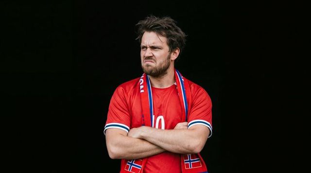 Frustrated norwegian football fan wearing number 10 jersey and scarf crossing arms