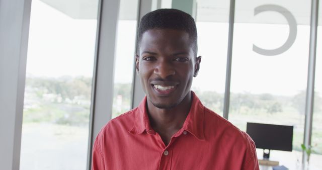 Smiling African American Man Wearing Red Shirt in Modern Office - Download Free Stock Images Pikwizard.com