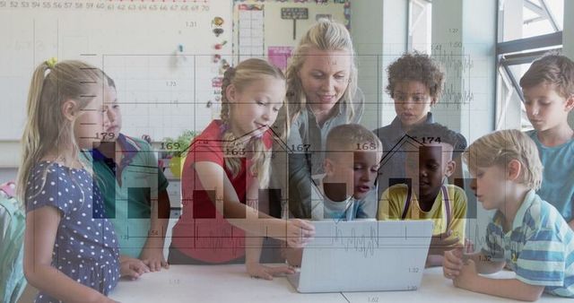 Teacher Guiding Enthusiastic Children in Classroom Learning on Laptop