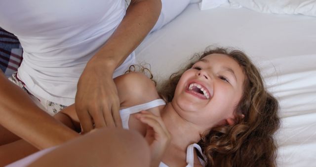 Mother Tickling Young Daughter Having Fun on Bed - Download Free Stock Images Pikwizard.com