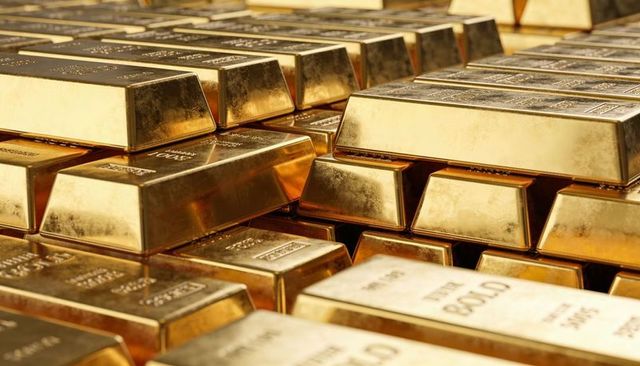 Stacked gold bars reflecting warm light in secure vault luxury bullion wealth investment
