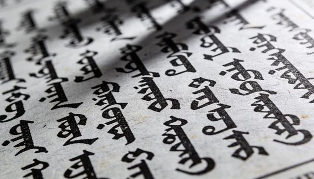 Displaying macro close-up of textured paper with bold black non-latin calligraphy