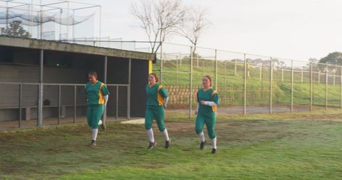 Female softball players jogging on field for team training