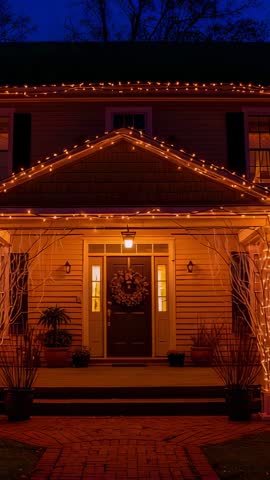 Cozy front porch glowing at dusk with orange string lights and wreath, vertical video