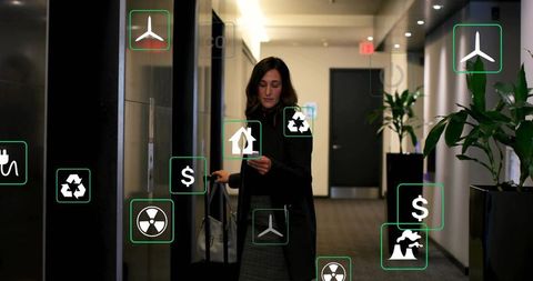 Business traveler checking phone in hotel corridor with luggage and sustainability icons