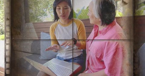 Intergenerational Tech Mentoring on Porch Bench with Laptop, Young Woman Teaching Older Woman