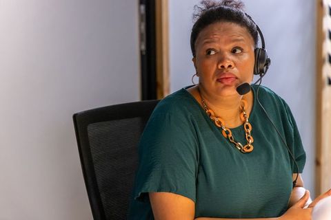 African american woman listening with headset at office workstation, customer support