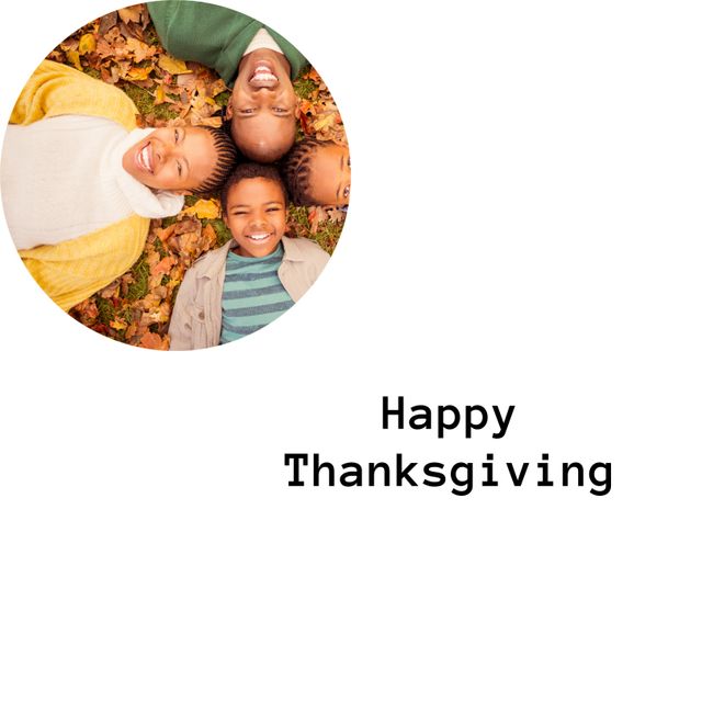 This image features a joyful African American family lying together in colorful autumn leaves, wishing a Happy Thanksgiving. Ideal for use in holiday greeting cards, social media posts, and advertisements celebrating family values and seasonal events.