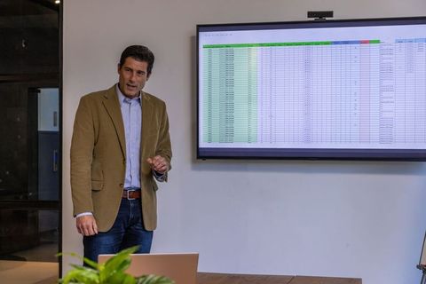 Businessman presenting spreadsheet data in modern office environment