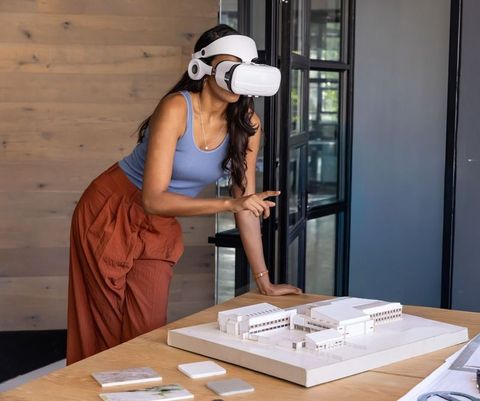 Indian designer exploring 3d architectural model with vr headset in modern studio
