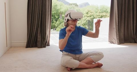 Senior Woman Exploring Virtual Reality with Headset Sitting on Carpet