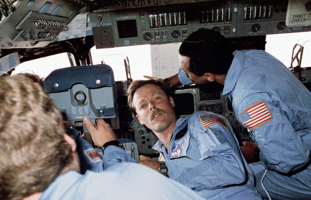 61C-21-009 (12-17 Jan 1986) --- Four members of the seven-man STS 61-C crew aboard the Columbia convene at the commander's station during the five-day mission which kicks off a busy 1986 for the Space Transportation System (STS).  Astronaut Robert L. Gibson (center frame), mission commander, is surrounded by (l.-r.).  Astronaut Steven A. Hawley, mission specialist, an unidentified crewmember (only partially visible) and astronaut Charles F. Bolden, pilot.