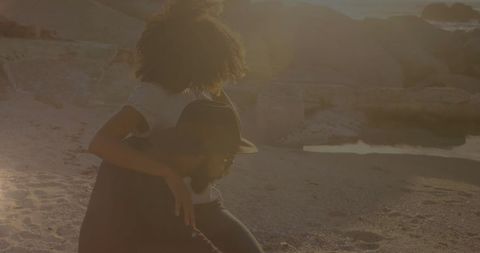 Young Couple Embracing on Sunlit Beach at Sunset