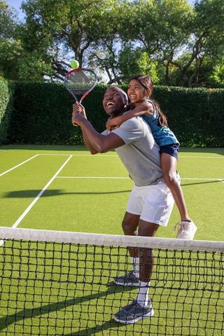 Father and Daughter Bonding Over Tennis on Sunny Day