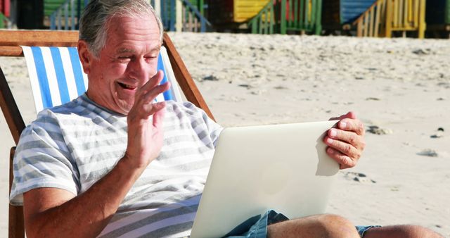 Senior Man Waving During Video Call On Beach With Laptop - Download Free Stock Images Pikwizard.com