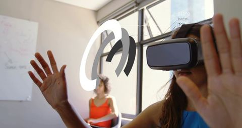 Young woman using vr headset interacting with holographic ui rings in modern office