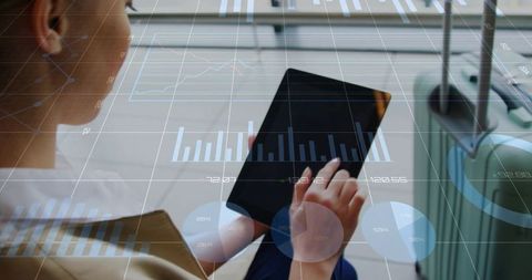 Business traveler using tablet in airport lounge with luggage and data analytics overlay