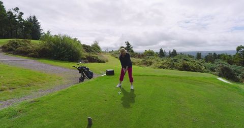 Senior Woman Preparing Golf Swing on Cloudy Day