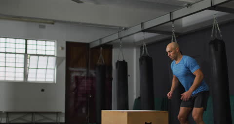 Athletic Trainer Performing Box Jumps in Gym Setting
