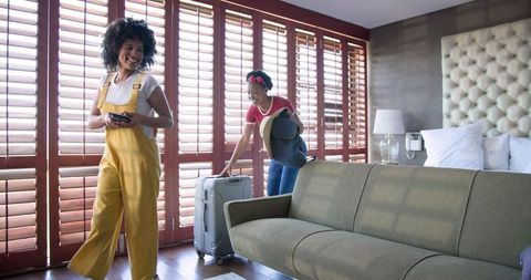 Diverse Female Couple Preparing for Vacation in Stylish Apartment