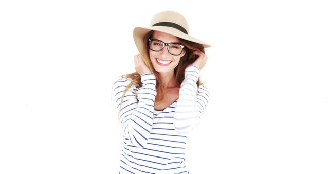 This image of a smiling woman wearing a hat and glasses is perfect for promoting fashion and lifestyle content. The white background makes it versatile for use in advertisements, social media campaigns, and website banners. Highlight her modern and trendy style to attract fashion-forward audiences.