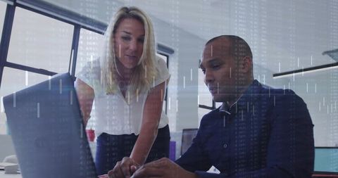 Business professionals collaborating over laptop with digital analytics overlay