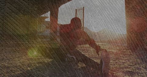 Runner resting under arch at sunrise catching low sun flare textured silhouette