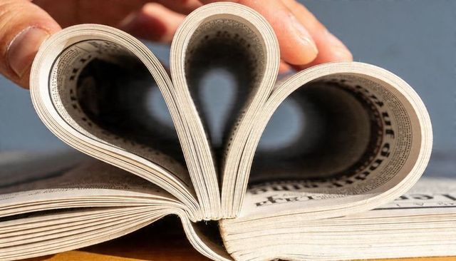 Triple heart pages forming love symbol from folded printed pages closeup