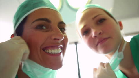 Smiling Surgeons in Operating Room Preparing for Surgery