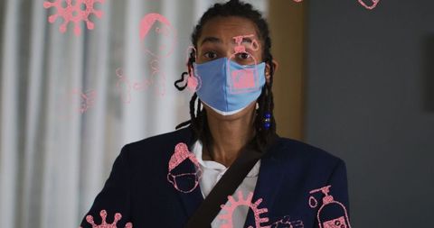 Biracial man with mask amidst covid-19 virus icons