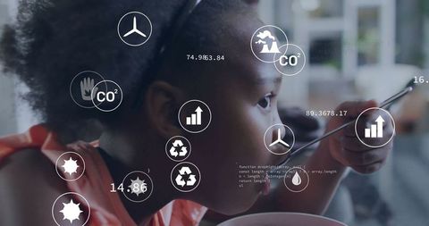 Child Engaging with Technology, Exploring Eco Symbols While Eating