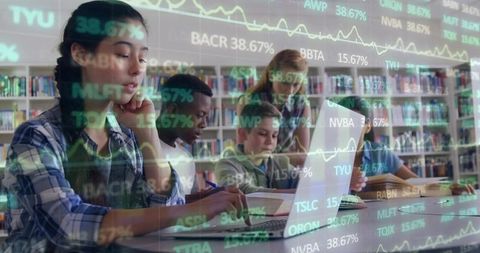 Teen Students Collaborating in Library Analyzing Financial Data with Laptops and Books
