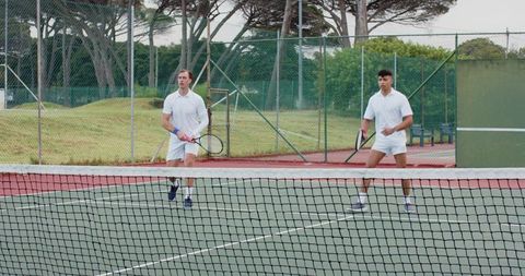 Doubles Tennis Partners Standing Ready at Net on Outdoor Hard Court Wearing White