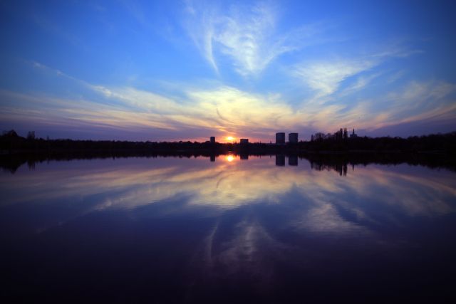 Stunning Sunset Reflecting on Calm Lake with Silhouetted City Skyline - Download Free Stock Photos Pikwizard.com