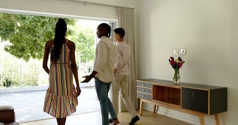 Young couple and estate agent chatting on bright patio