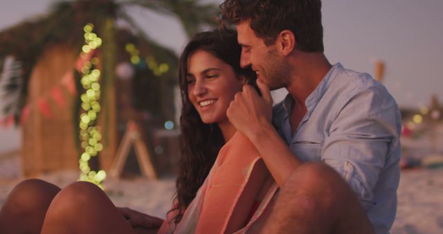 Happy couple embracing on beach and smiling by beach bar. Summer, free time, romance, relaxation and vacations.