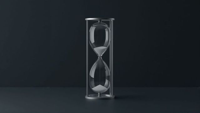 Minimalist hourglass on desk with flowing sand symbolizing timelessness