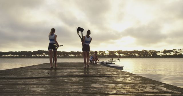 Rowers preparing boat on lake pier at sunrise - Download Free Stock Images Pikwizard.com