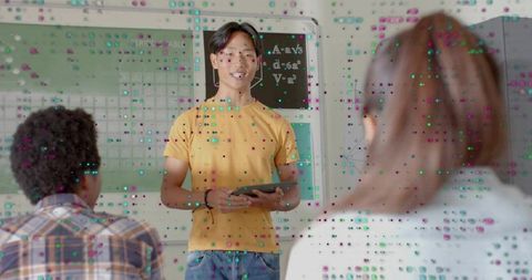 Asian teen presenting with tablet in classroom engaging classmates during lesson