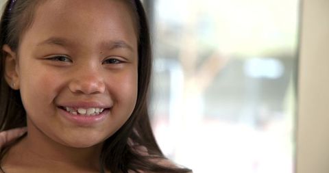 Smiling Child in Sunlit Room with Purple Headband