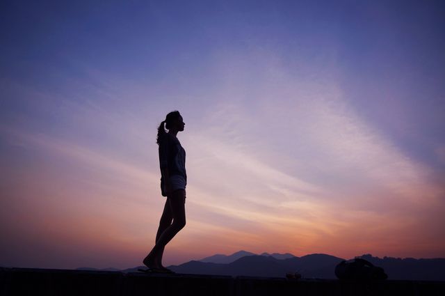 Silhouette of Woman Standing Against a Vibrant Sunset - Download Free Stock Photos Pikwizard.com