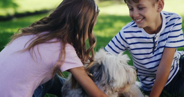 Children enjoying time outdoors in a sunny park, petting and interacting with their dog. Ideal for ads promoting family-friendly products, outdoor activities, pet supplies, or summer-related campaigns. Can be used in blog posts about parenting, pet care, or outdoor activities for kids.