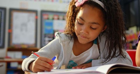 Young African American Girl Focused on Drawing in School Classroom