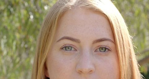 Serene Woman Gazing in Lush Garden with Green Foliage